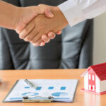 hands of agent and client shaking hands after signed contract bu